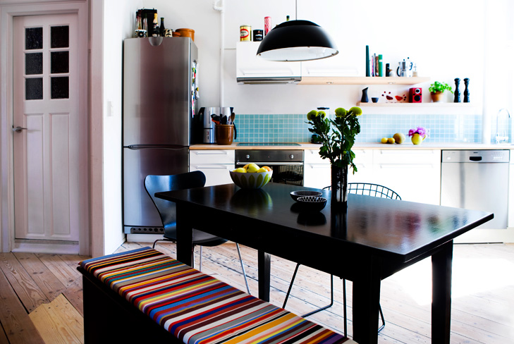 Indretning af køkken og spiseplads i samtale køkken. Spisebord med blomster på