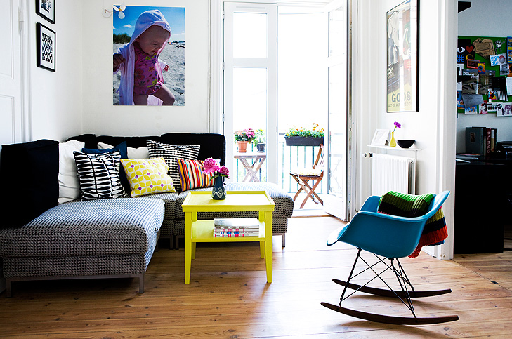 Interior decoation of small living room with a sofa, a yellow sofa table and a large poster with a kid